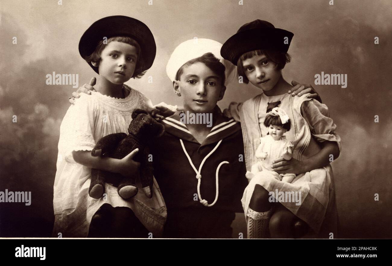 1920 ca , Napoli , ITALY  : Three brothers with toys  . - TOY - giocattolo - giocattoli  -  BAMBOLA - bambole - FRATELLI -  SORELLE - SISTERS - TEDDY BEAR - ORSACHIOTTO - FOTO STORICHE - HISTORY PHOTOS  - children  - child  - bambina  - BAMBINO - BAMBINI - CHILDREN - BABY - babies -  INFANZIA  -   - NOVECENTO - DOLL - DOLLS - NOVECENTO - 900's - '900  - gioco - giochi - vestito abito alla marinara - marinaretto - marinaretta - hat - cappello - pizzo - lace - peluches - CHILDHOOD - INFANZIA --- Archivio GBB Stock Photo