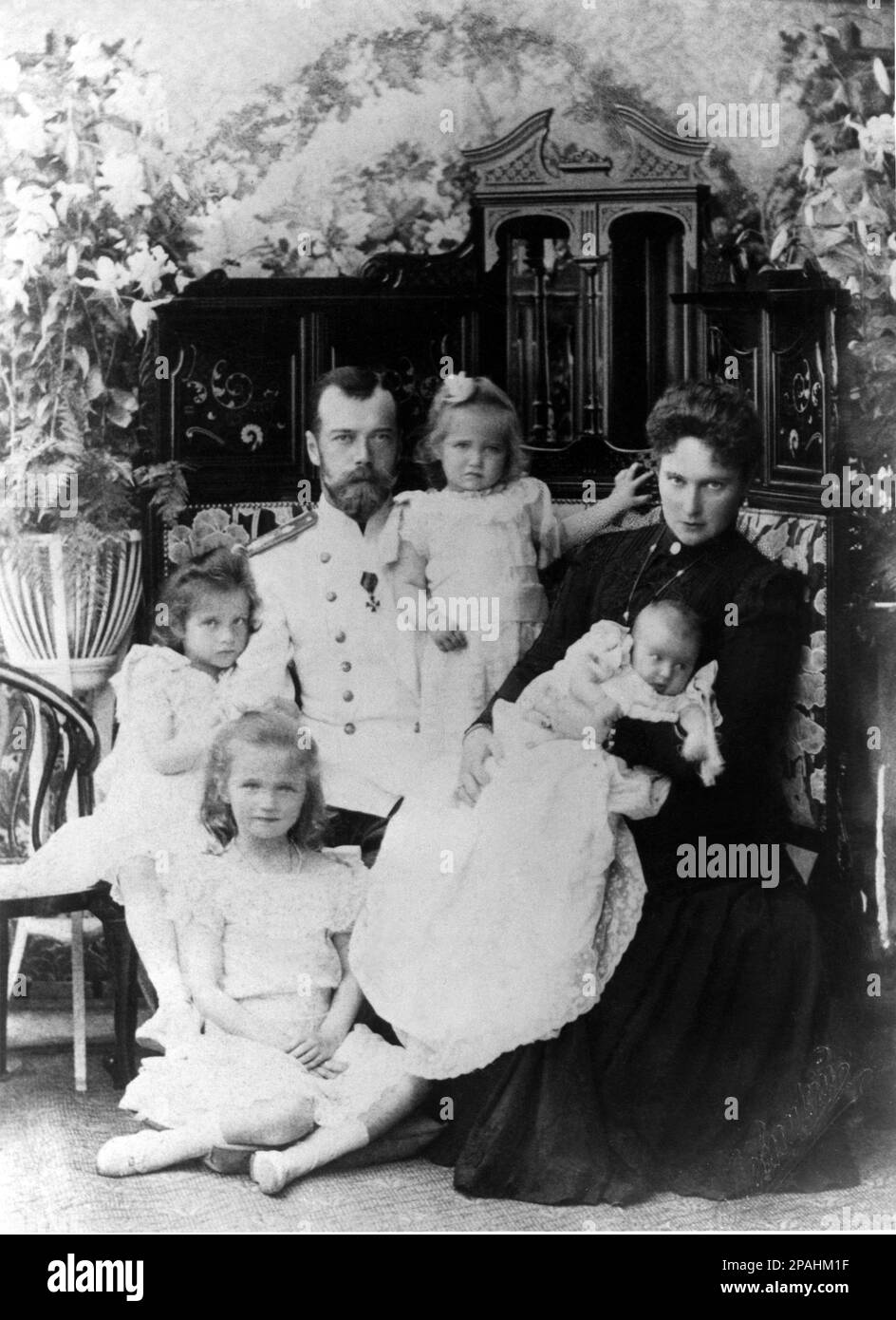 1901 :  The russian Tsar NICHOLAS II of Russia ( 1868– 1918)  with wife Empress Tsarina ALEXANDRA FYODOROVNA ( Feodorovna , Alix of Hesse and by Rhine 1872 - dead the day  17 July 1918 with all the royal family ). In this photo with daughters :  MARIE ( Maria , born 1899 ), TATIANA ( born 1897 ), ANASTASIA ( born 1901 )in the hands of Tsarina and OLGA (born  1895 )- HISTORY  foto storiche - foto storica   - portrait - ritratto - nobilta'  - nobility - nobili  - nobile - BELLE EPOQUE  - RUSSIA - ZAR - Czar - Tsarine -   TZARINA - ZARINA  - RUSSIA - ROMANOFF - ROMANOV - pizzo - lace - jewellery Stock Photo