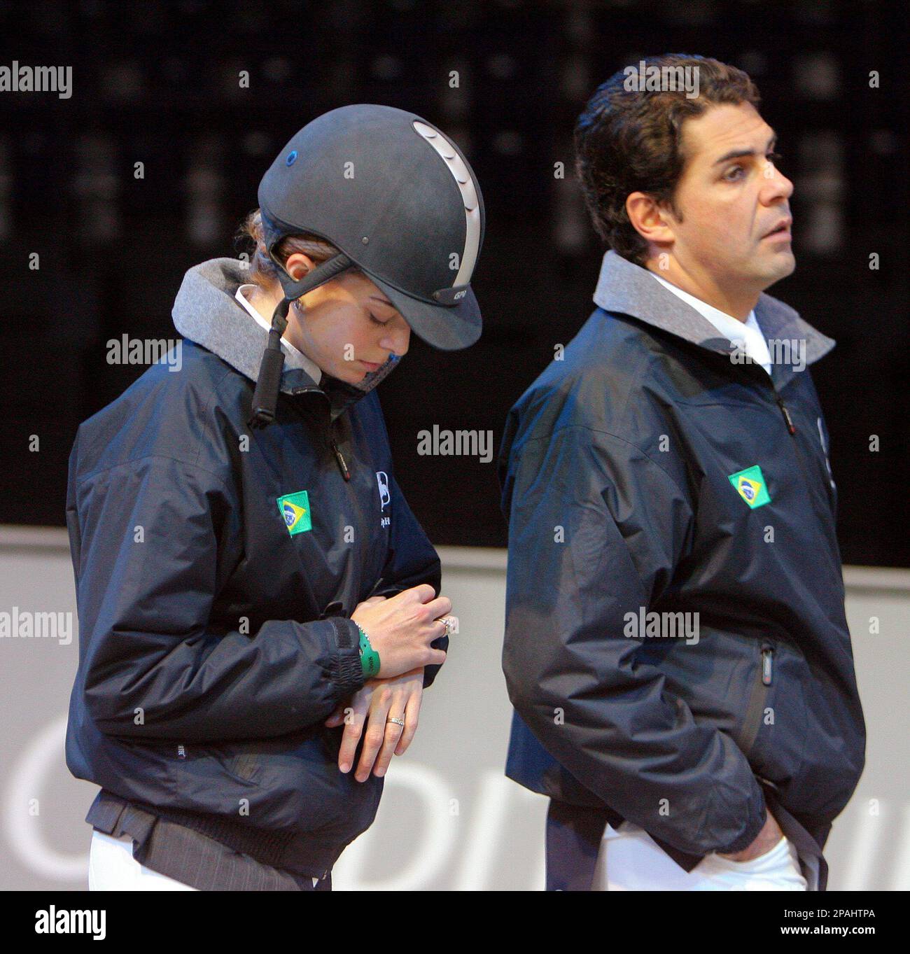 Greek rider Athina Miranda-Onassis, left, checks her watch as she and her  husband, Brazilian Alvaro Miranda, right, inspect the show-jumping course  prior to the Liebherr Prize event at the CSI Show Jumping