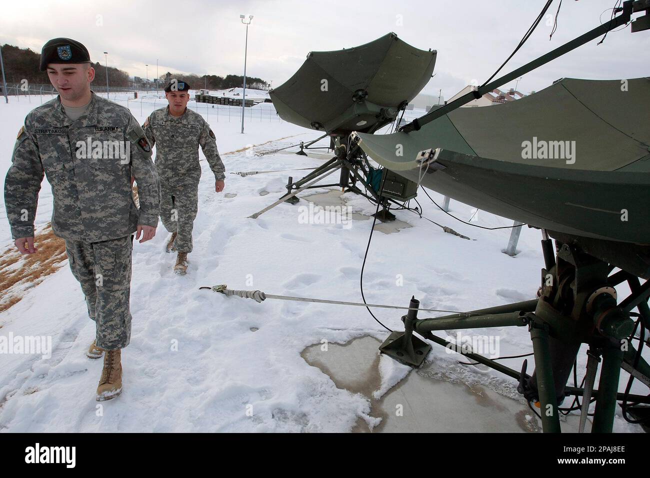 U.S. Army soldiers walk past the Joint Tactical Ground Station, JTAGS