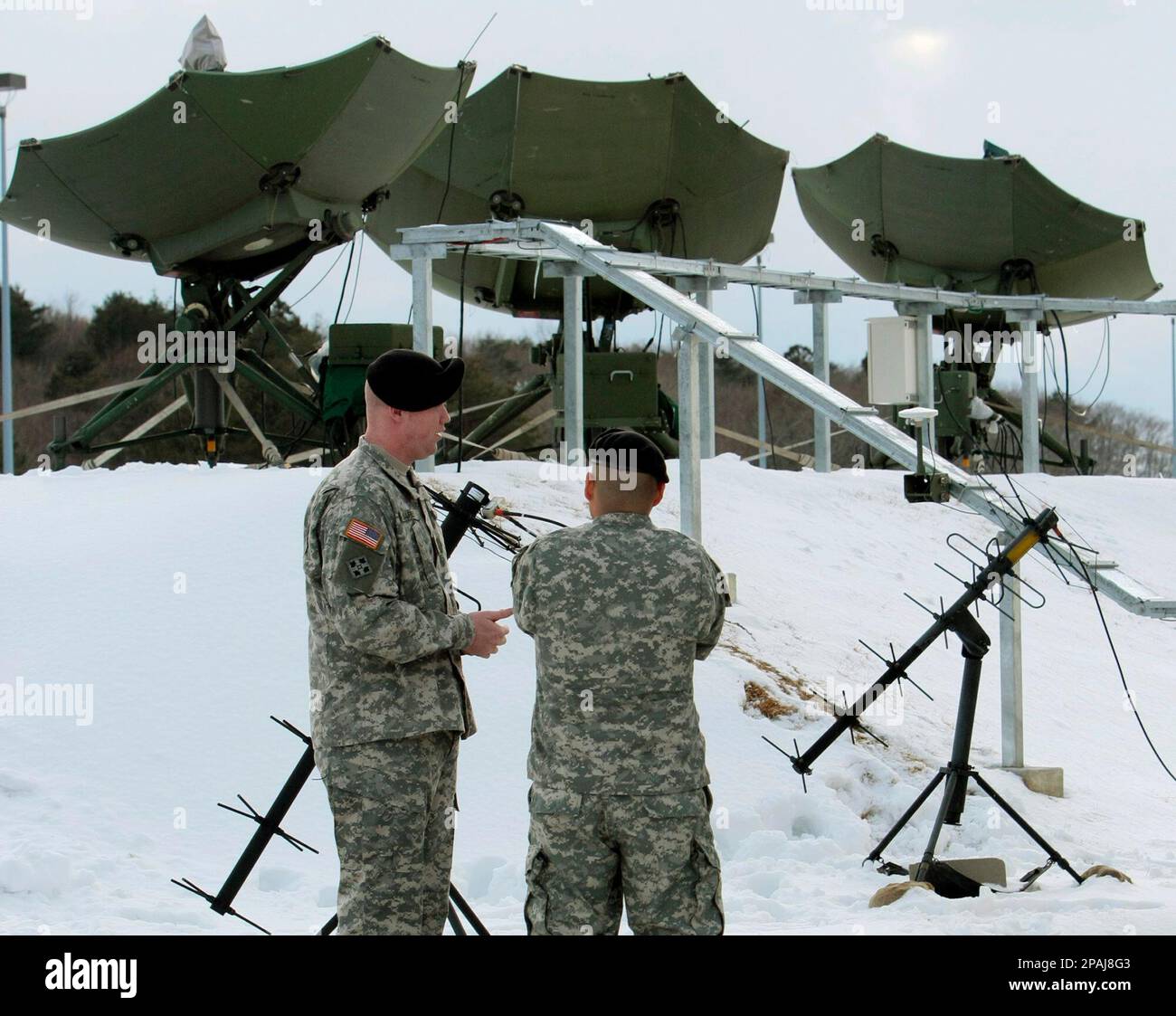 U.S. Army soldiers walk past the Joint Tactical Ground Station, JTAGS