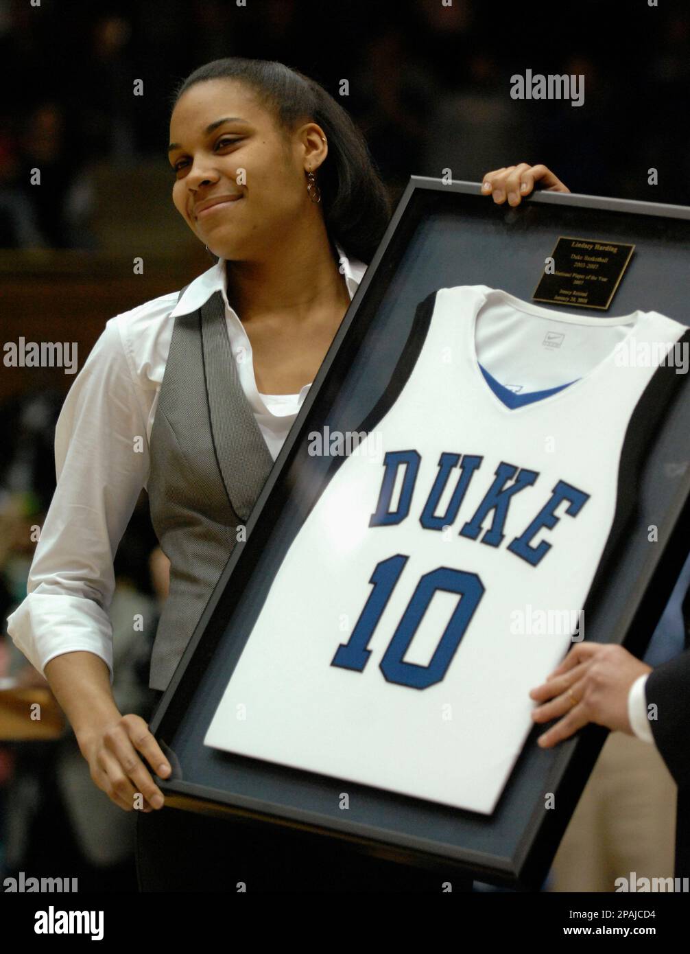 Duke's former player Lindsey Harding, National Player of the Year and  All-American, holds up her framed jersey during her jersey retirement  ceremony at half-time of a basketball game in Durham, N.C., Sunday