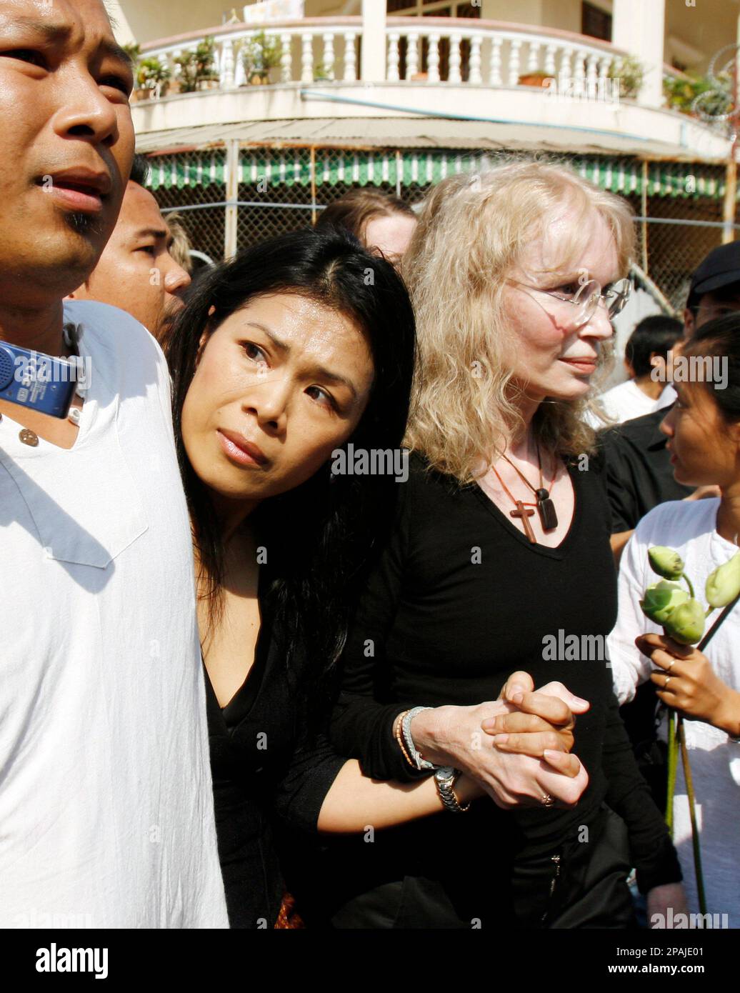 American actress Mia Farrow, right, and Cambodian Executive Director of the Center for Social Development, Theary Seng, left, move away after police pushing their group outside Tuol Sleng genocide museum in Phnom Penh, Cambodia, Sunday, Jan. 20, 2008. Cambodian police blocked American actress Mia Farrow from holding a genocide memorial ceremony Sunday at a Khmer Rouge prison, at one point forcefully pushing her group away from a barricade. (AP Photo/Heng Sinith) Stock Photo