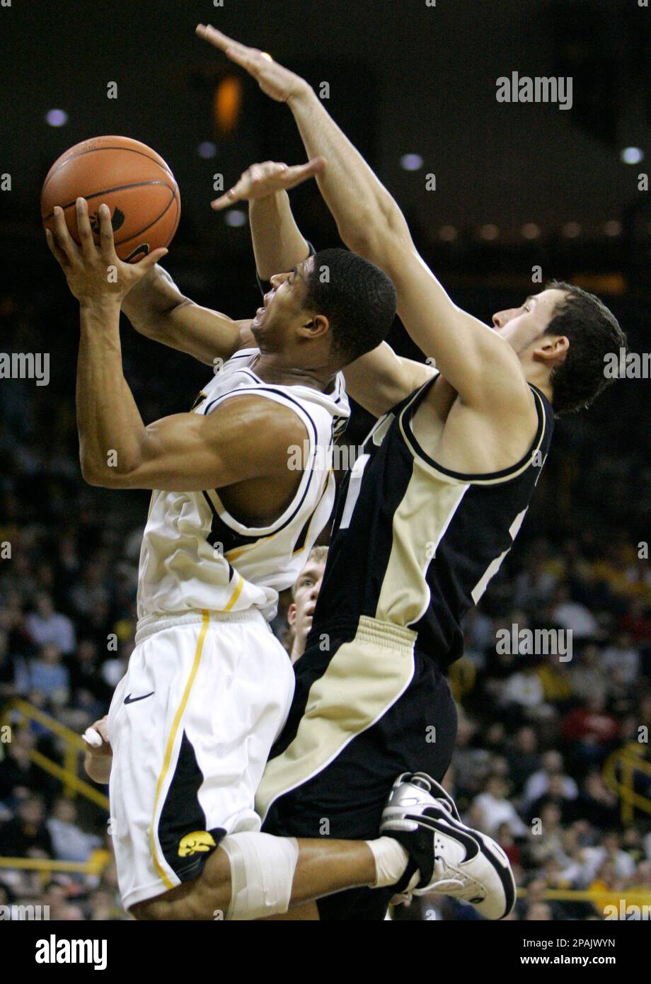 Iowa's Tony Freeman, left, drives to the basket past Purdue's Nemanja
