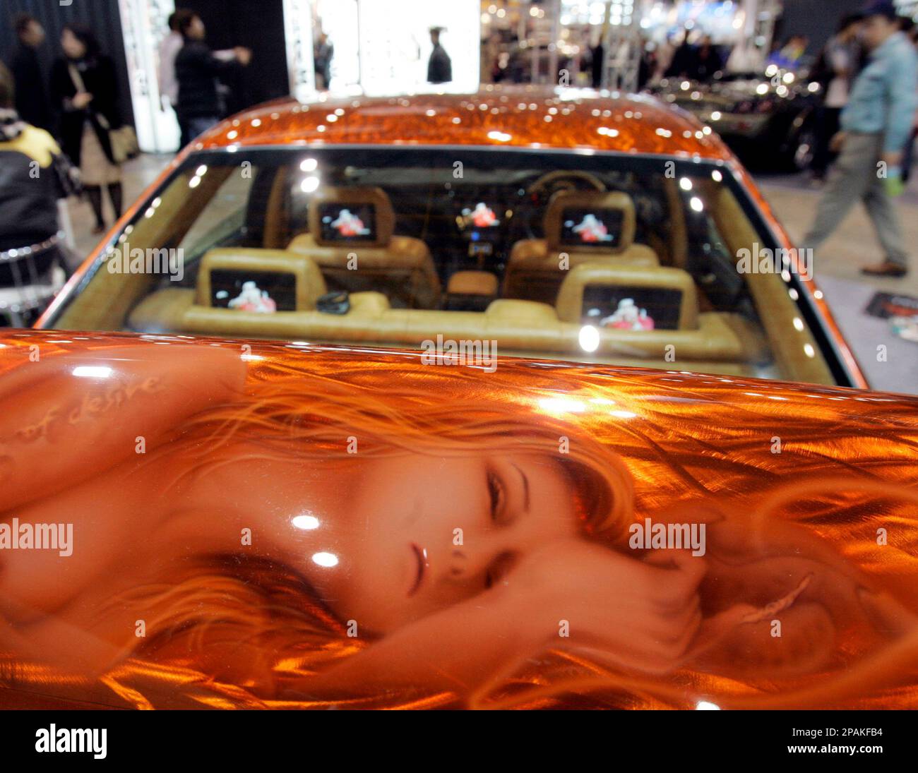 A visitor walks by a car painted by Japanese auto body paint shop Kikuta during a Tokyo Auto