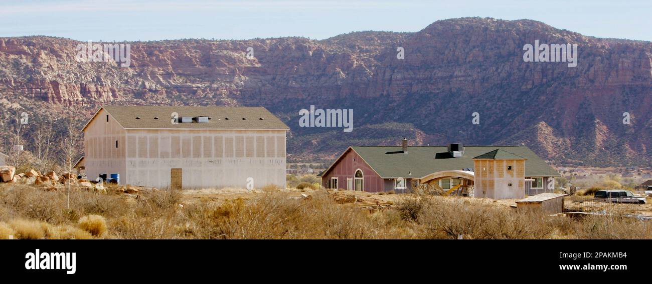 Unfinished houses covered with painted sheets of plywood are occupied