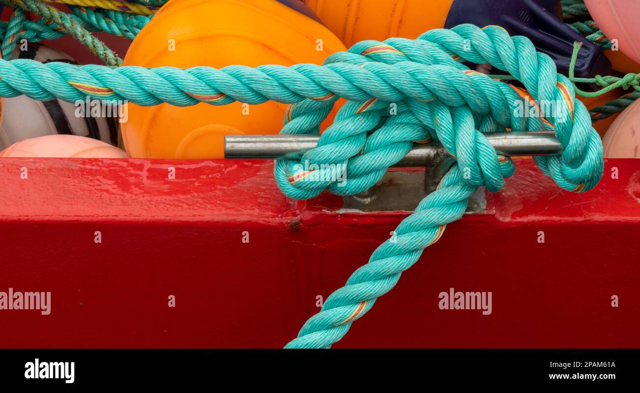 Colourful abstract of a mooring cleat with a rope tied to it. Stock Photo
