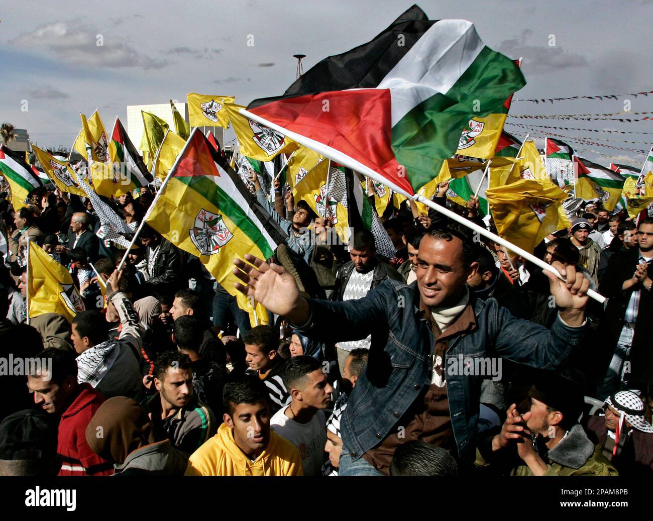Palestinian Fatah supporters hold up yellow Fatah flags and Palestinian