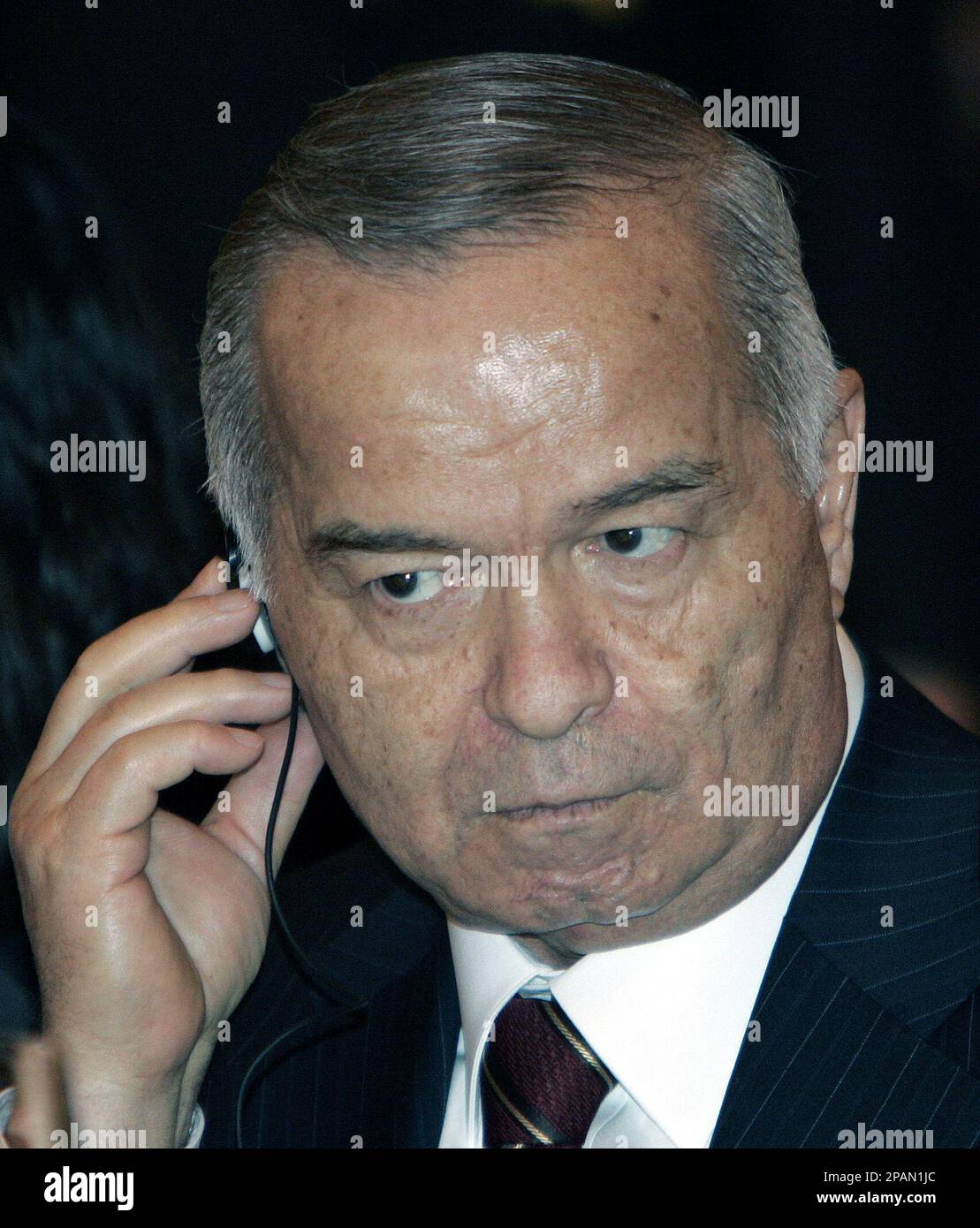 FILE Uzbek President Islam Karimov adjusts his earpiece during