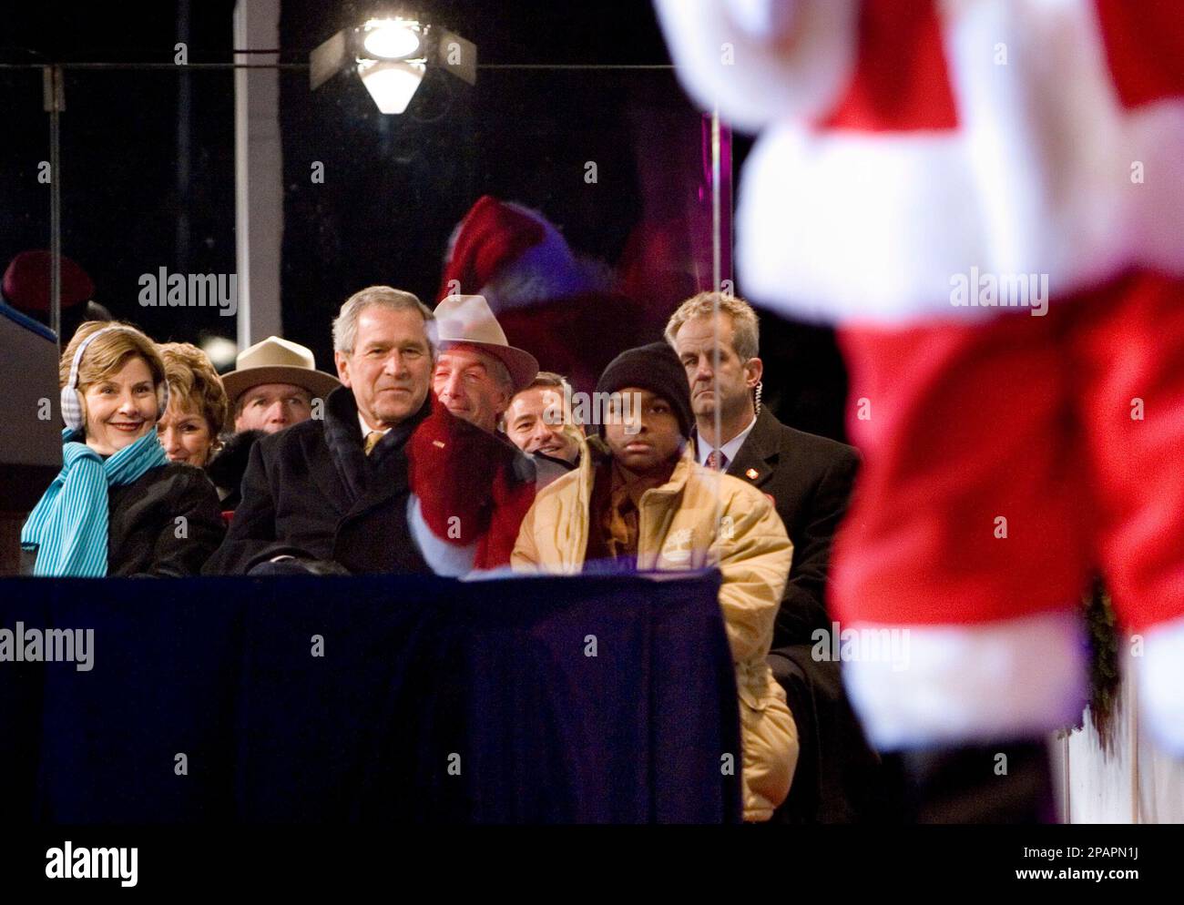 President Bush and first lady Laura Bush smile as Santa takes the stage ...