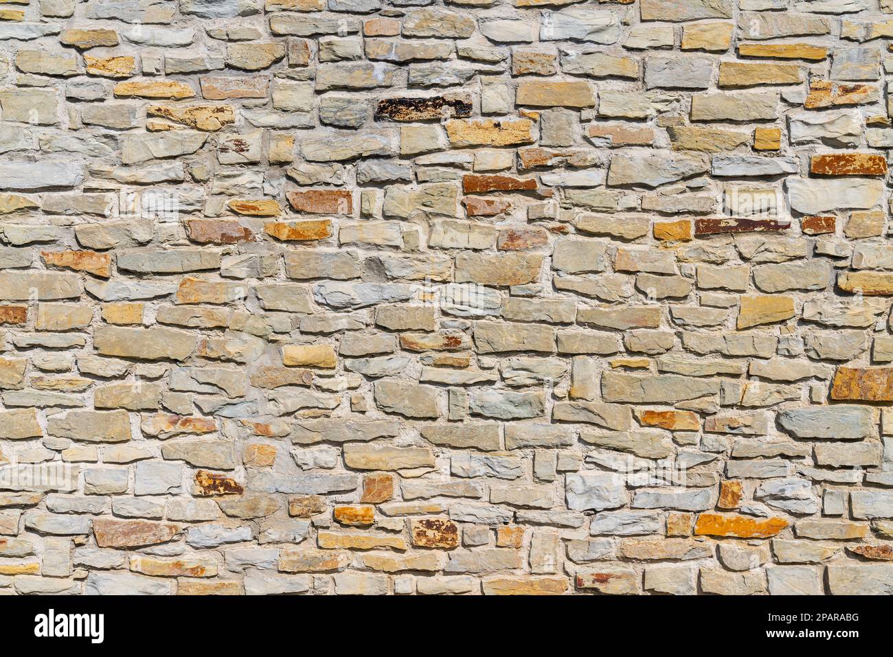 A fragment of a city wall of hewn stone on cement mortar. Stones of