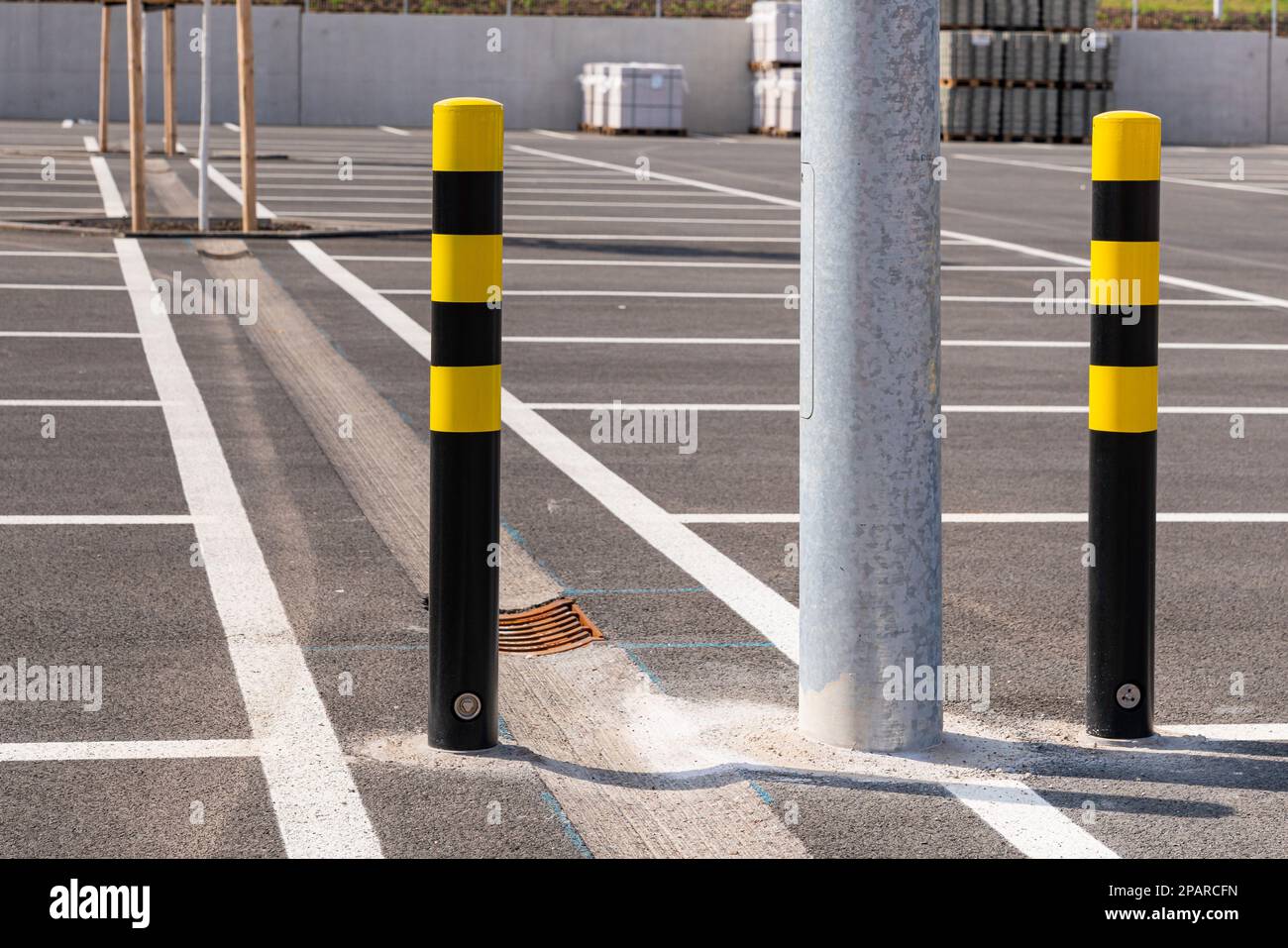 Black and yellow bollards in the great parking lot. Lines for parking