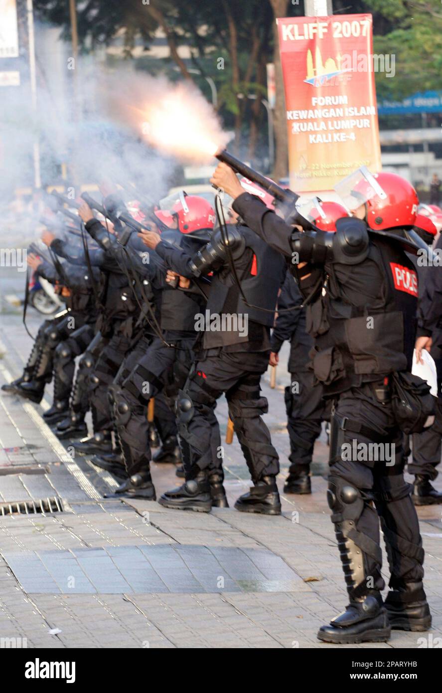 Malaysian riot police officers fire tear gas during a street protest by ...