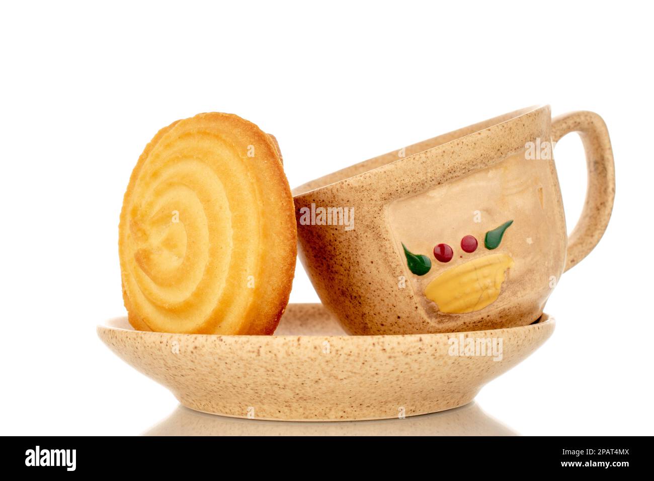 One sweet cookie on a ceramic saucer with a cup, macro, isolated on white background. Stock Photo
