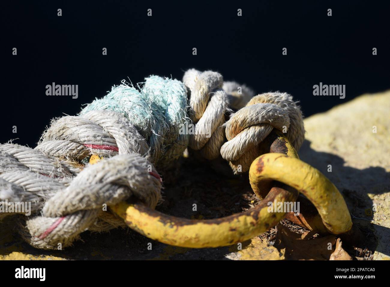Old weathered heavy duty double braided mooring rope attached to a ...