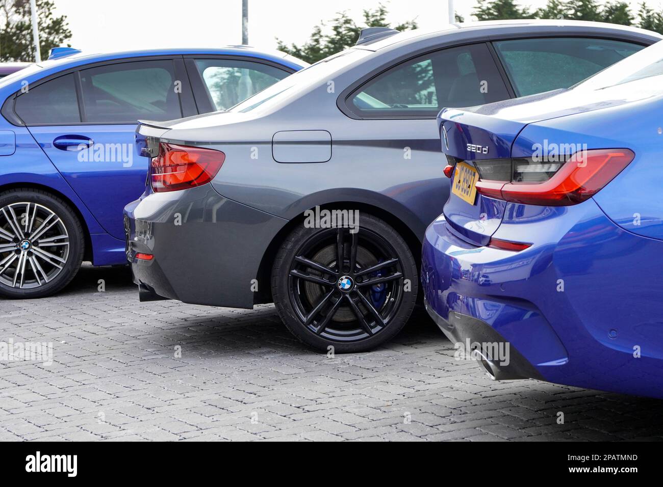 Selection of secondhand BMW cars for sale in a garage forecourt, UK