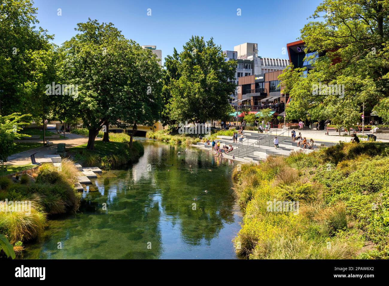 31 December 2022: Christchurch, New Zealand - People enjoying a summer day at The Terrace, a new riverside development, sitting on the steps by the ri Stock Photo