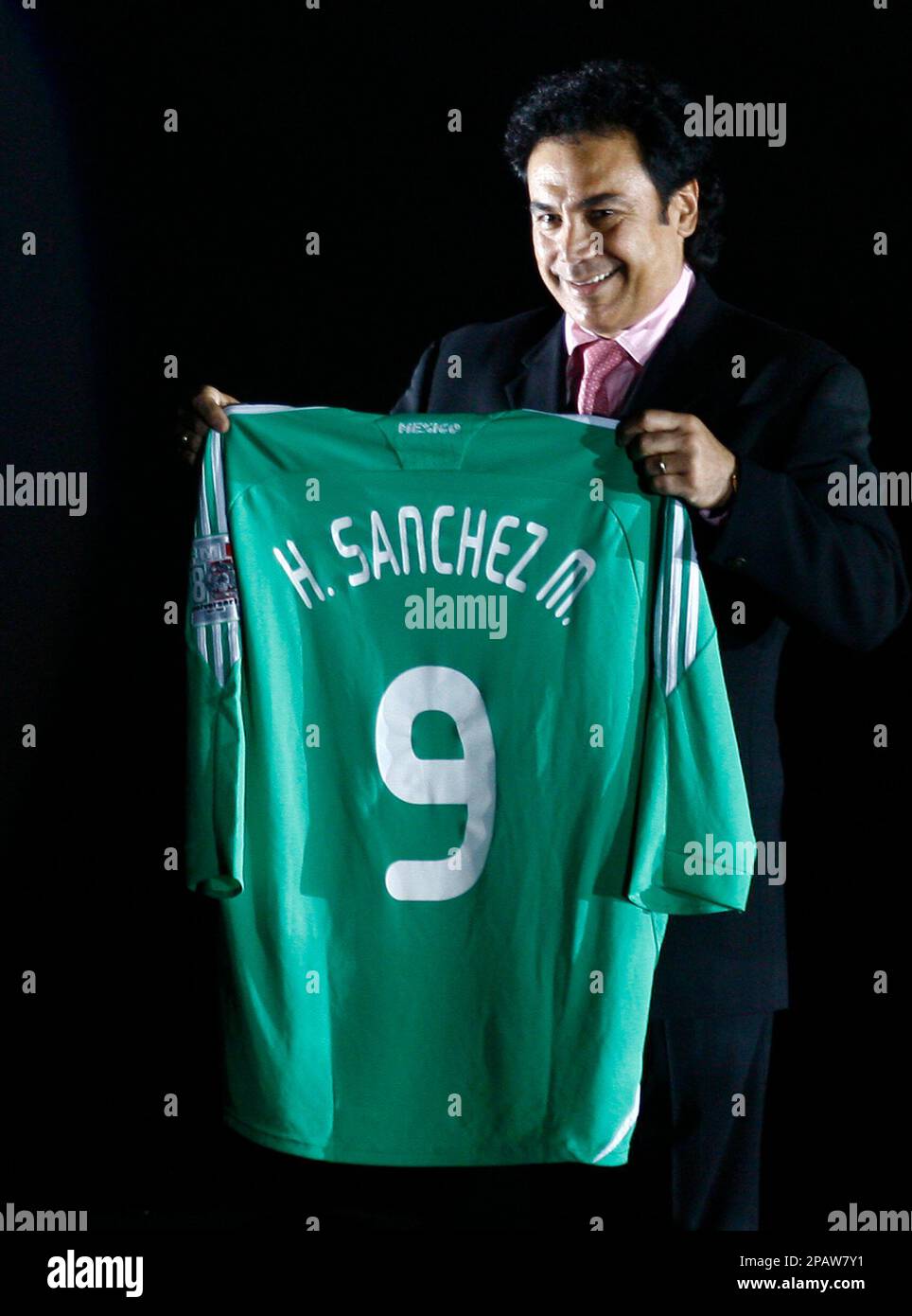 Mexico s national soccer coach Hugo Sanchez holds a model of the new Mexico s national soccer team