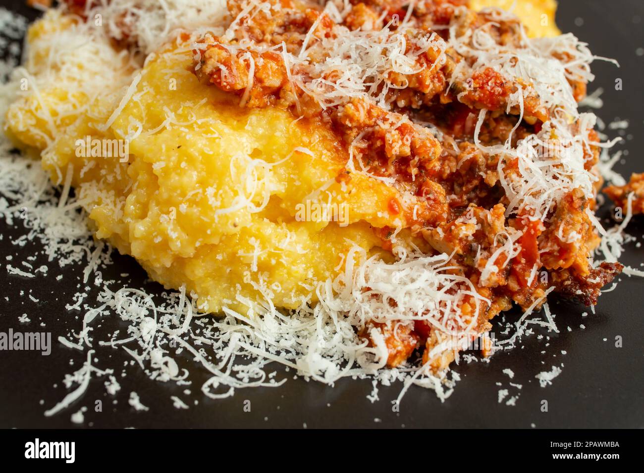 Boiled corn flour, mamaliga,  polenta, with minced pork meat and tomato sauce, ragu, soft focus close up texture Stock Photo