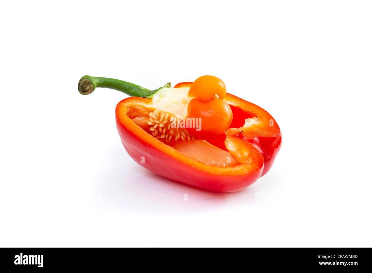 baby bell pepper inside a cross sectioned pepper, isolated on white