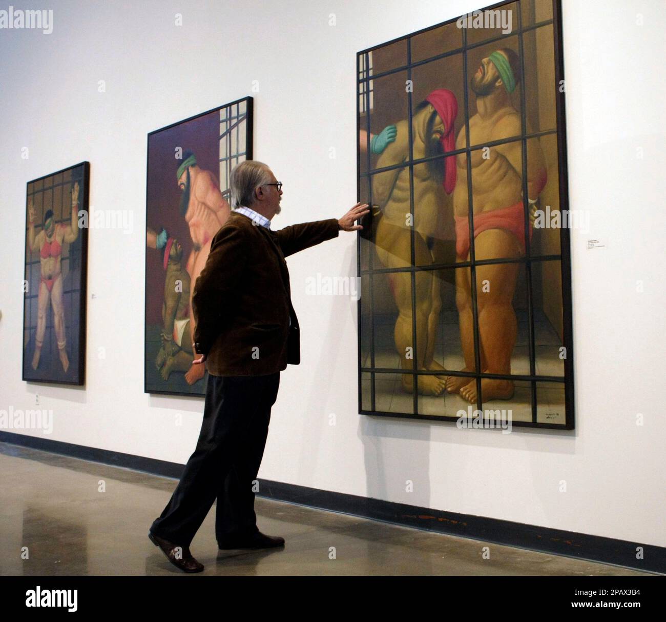 ** EDS NOTE: GRAPHIC CONTENT ** Colombia artist Fernando Botero looks over one of his works at a first complete U.S. showing of "Art of Confrontation," his seventy-nine paintings and drawings on Abu Ghraib prison, Monday, Nov. 5, 2007, at American University Museum in Washington.(AP Photo/Pablo Martinez Monsivais) Stock Photo