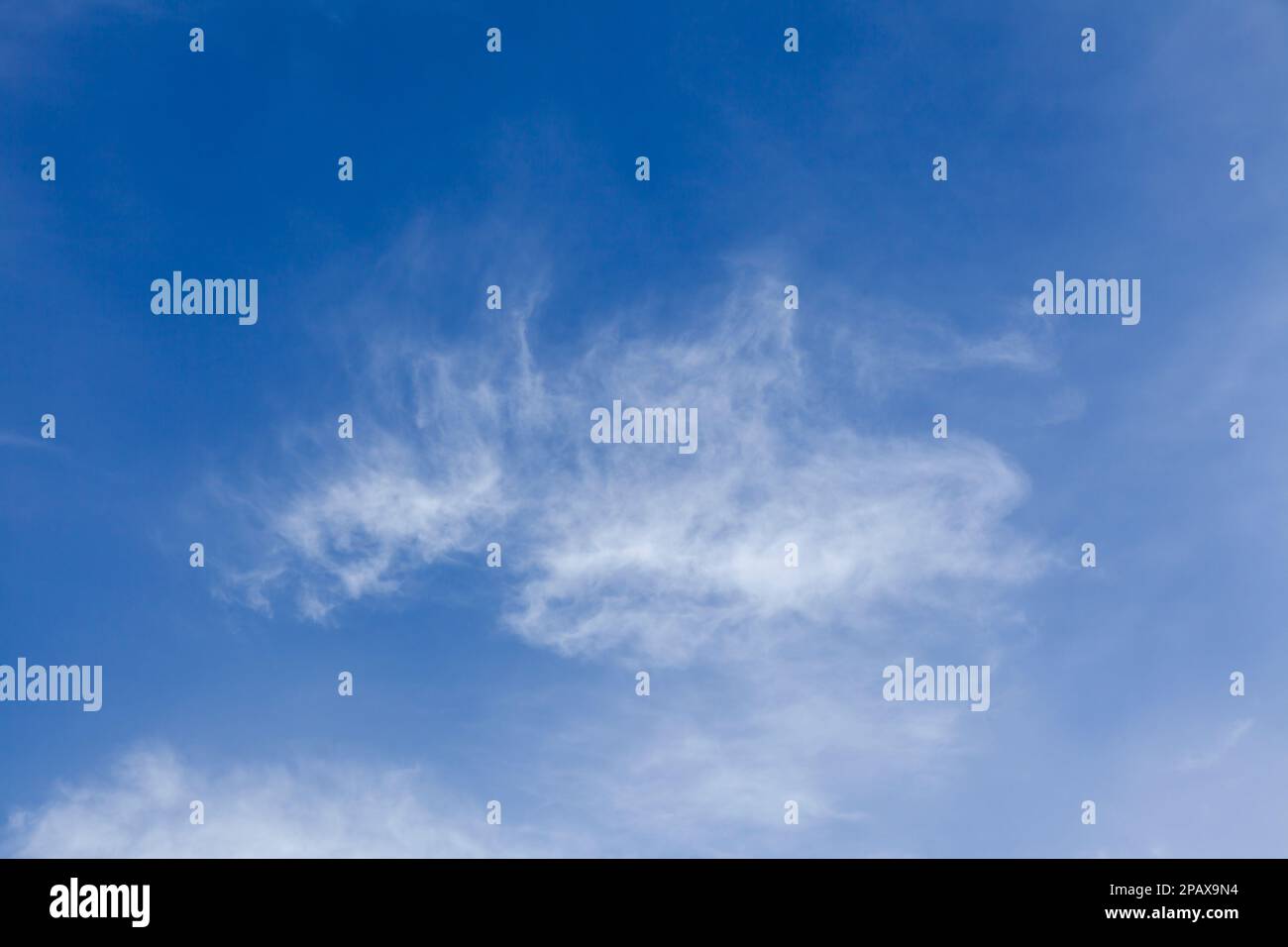 Blue sky with white wispy clouds background Stock Photo - Alamy