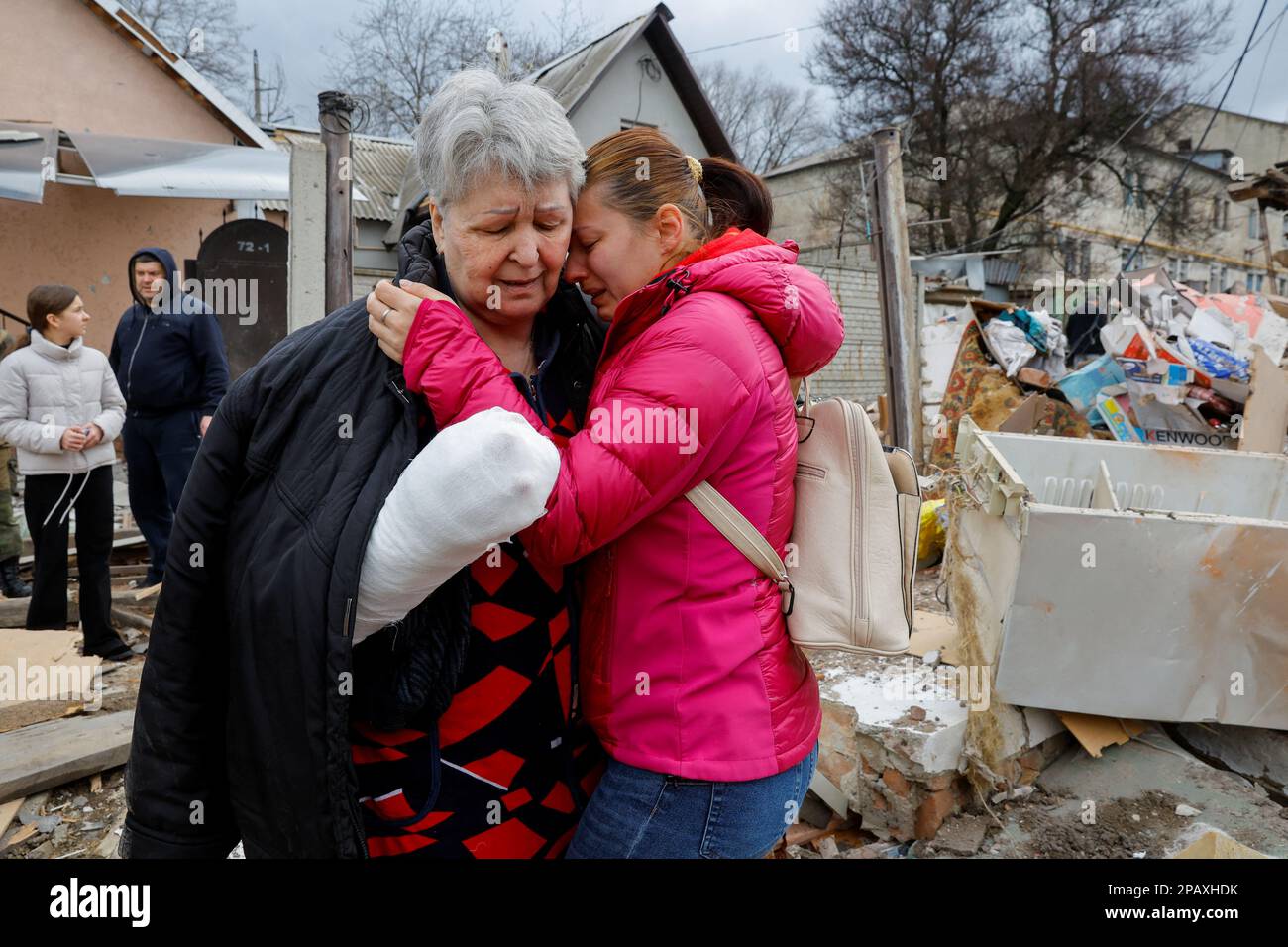Local resident Svetlana Boiko, 66, who was injured in recent shelling, is comforted by her acquaintance Yulia Kryukova while standing near her destroyed house in the course of Russia-Ukraine conflict in Donetsk, Russian-controlled Ukraine, March 12, 2023. REUTERS/Alexander Ermochenko     TPX IMAGES OF THE DAY Stock Photo