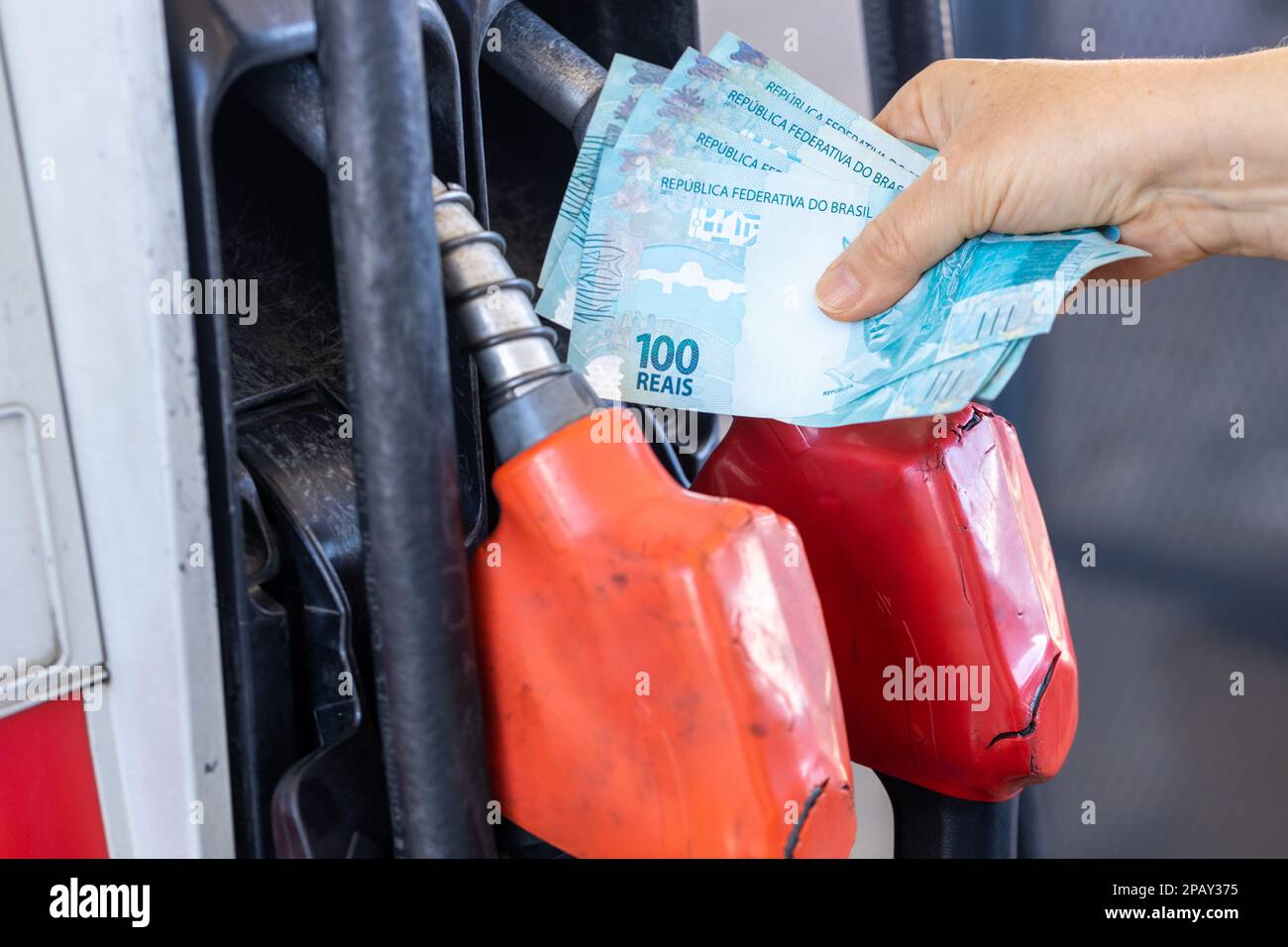 Brazil, gas station woman holding a handful of money, concept, gas