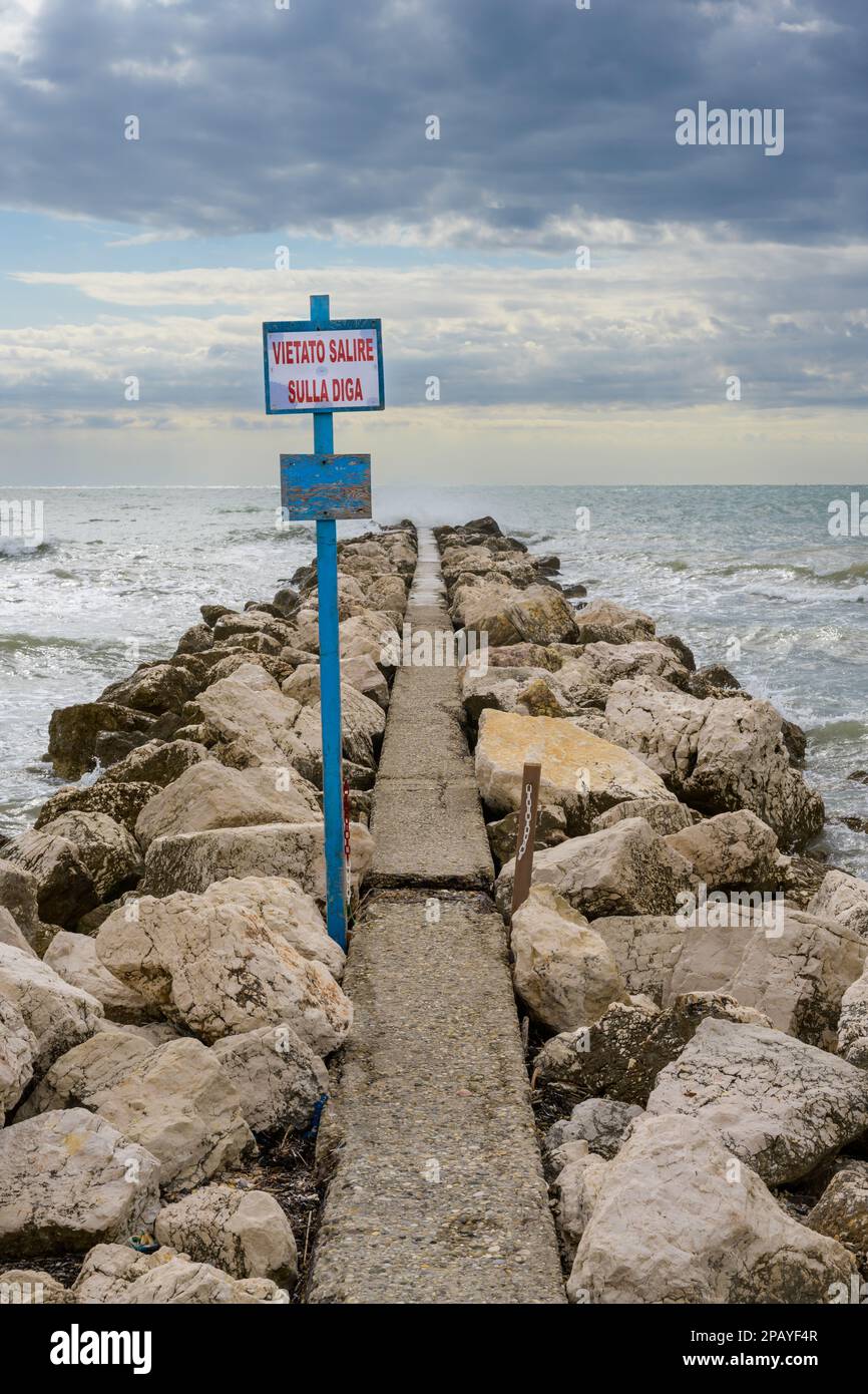 Breakwater Dam on Lido di Venezia Beach in Venice, Italy with Sign reading Vietato Salire Sulla Diga - It is forbidden to climb the Dam Stock Photo