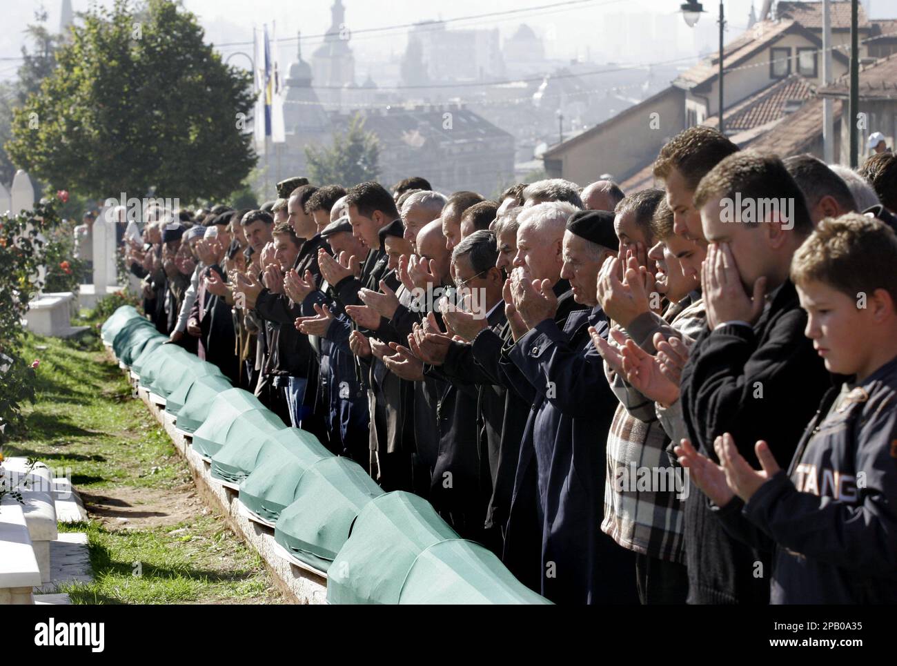 Bosnian Muslims pray at the funeral of 37 victims killed at the