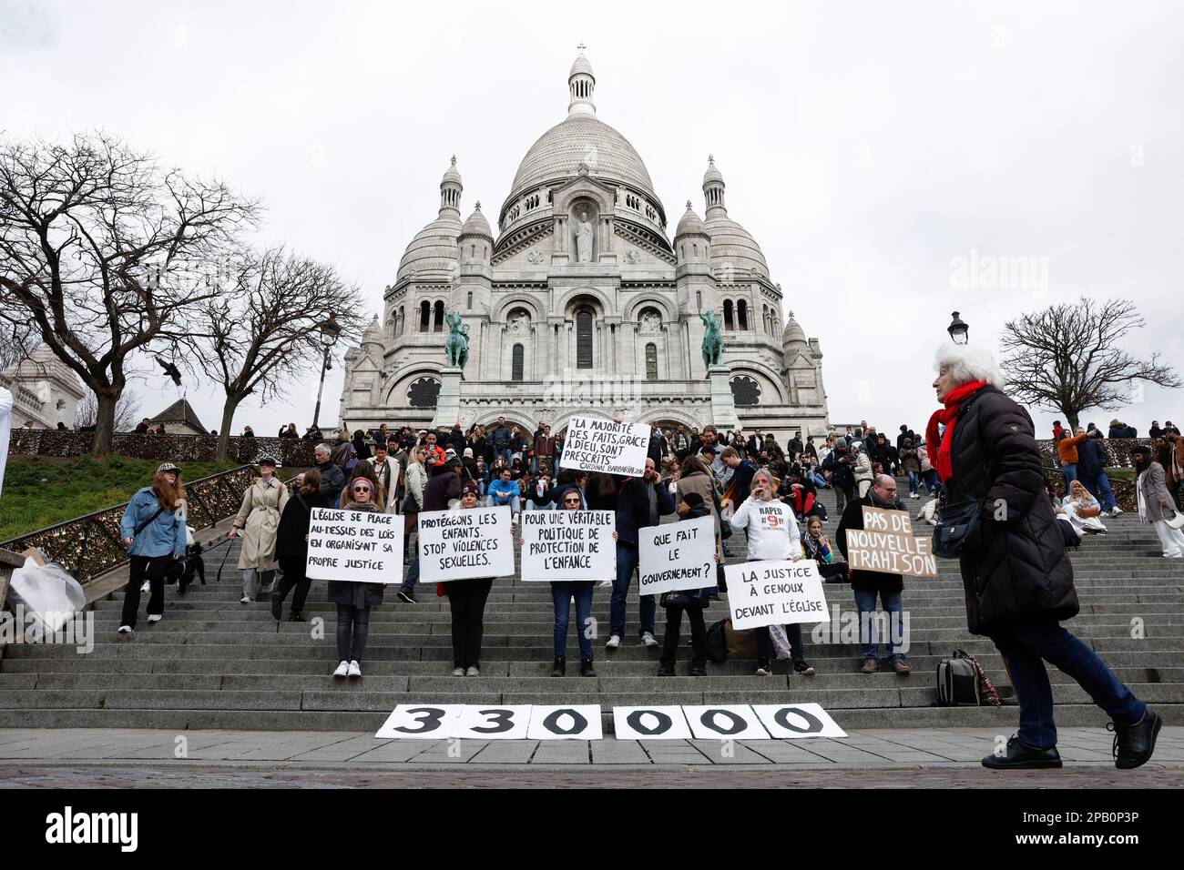 People participate in a gathering organised by Tous Ensemble and Be Brave France associations to support the victims of sexual abuse by the French Catholic Church, outside the Sacre-Coeur Basilica at the Butte Montmartre in Paris, France, March 12, 2023. REUTERS/Benoit Tessier Stock Photo