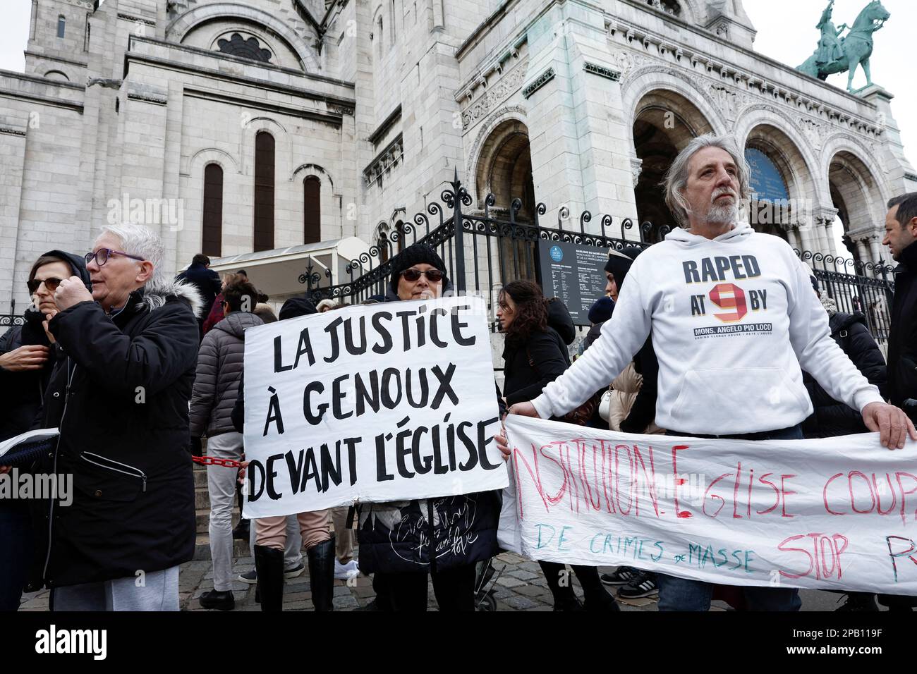 People participate in a gathering organised by Tous Ensemble and Be Brave France associations to support the victims of sexual abuse by the French Catholic Church, outside the Sacre-Coeur Basilica at the Butte Montmartre in Paris, France, March 12, 2023. The placard reads 'Justice on its knees before the church'. REUTERS/Benoit Tessier Stock Photo