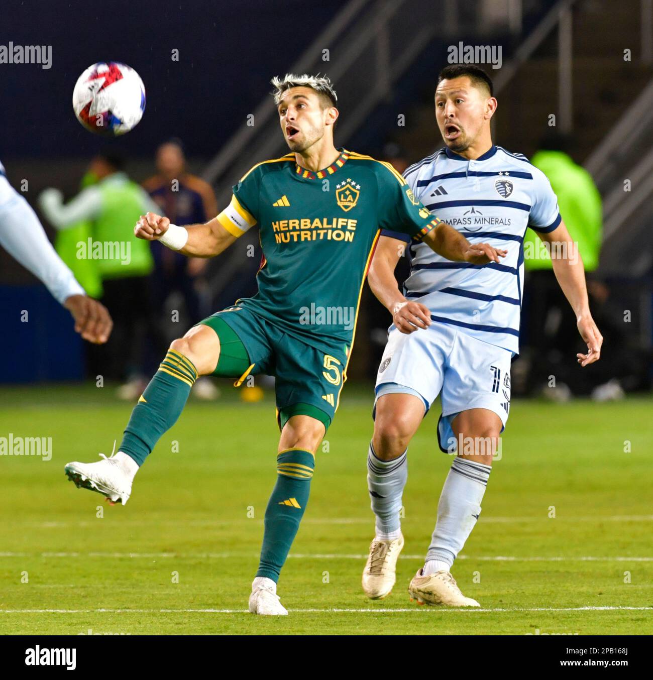 Kansas City, USA. 11th Mar, 2023. Los Angeles Galaxy midfielder Gastón Brugman (5) and Sporting Kansas City midfielder Roger Espinoza (15) watch the ball drop. Sporting KC hosted the LA Galaxy in a Major League Soccer game on March 11, 2023 at Children's Mercy Park Stadium in Kansas City, KS, USA. Photo by Tim Vizer/Sipa USA Credit: Sipa USA/Alamy Live News Stock Photo
