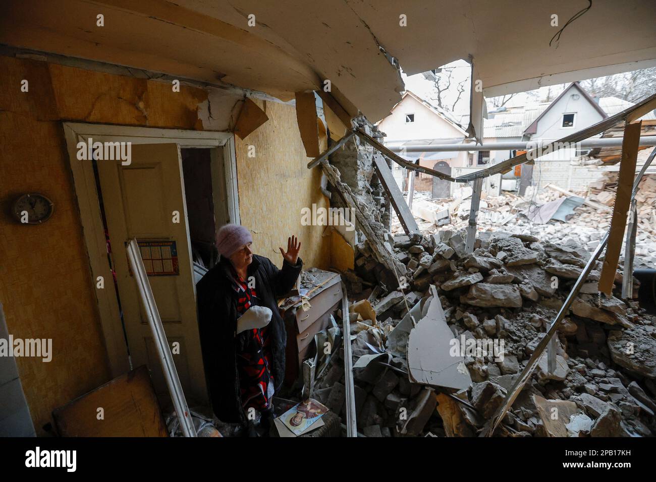 Local resident Svetlana Boiko, 66, who was injured in recent shelling, reacts outside her destroyed house in the course of Russia-Ukraine conflict in Donetsk, Russian-controlled Ukraine, March 12, 2023. REUTERS/Alexander Ermochenko Stock Photo