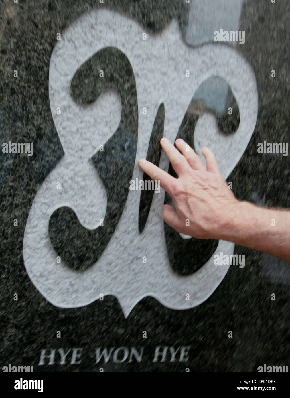 A visitor touches a symbol, meaning "imperishability and endurance" on