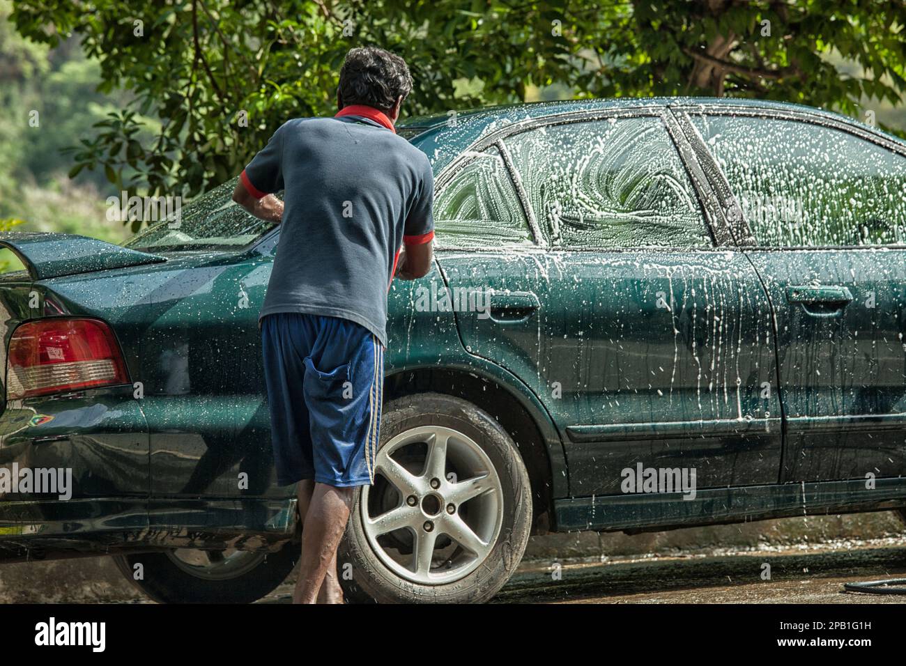 Man washing his car by hand outdoors with soap Stock Photo Alamy
