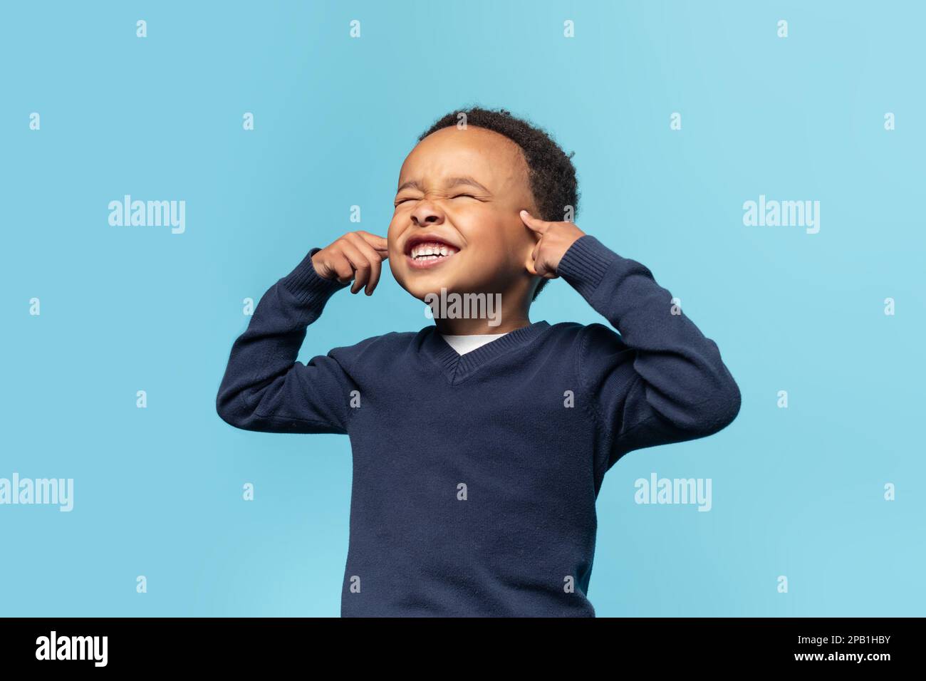 Funny black boy touchig his temples and closing eyes, kid trying to