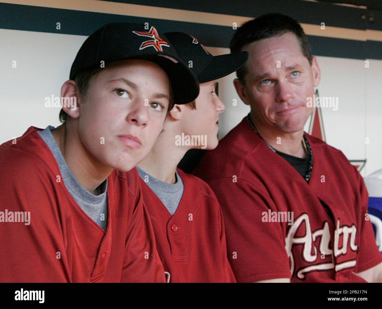 Houston Astros' Craig Biggio, right, gets emotional as he sits in the  dugout with his sons Connor, left, and Cavan and watches a tribute from his  family during the last baseball game