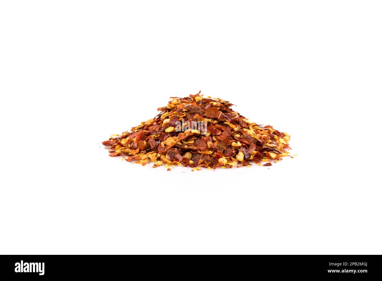 The pile of a crushed red pepper, dried chili flakes and seeds isolated