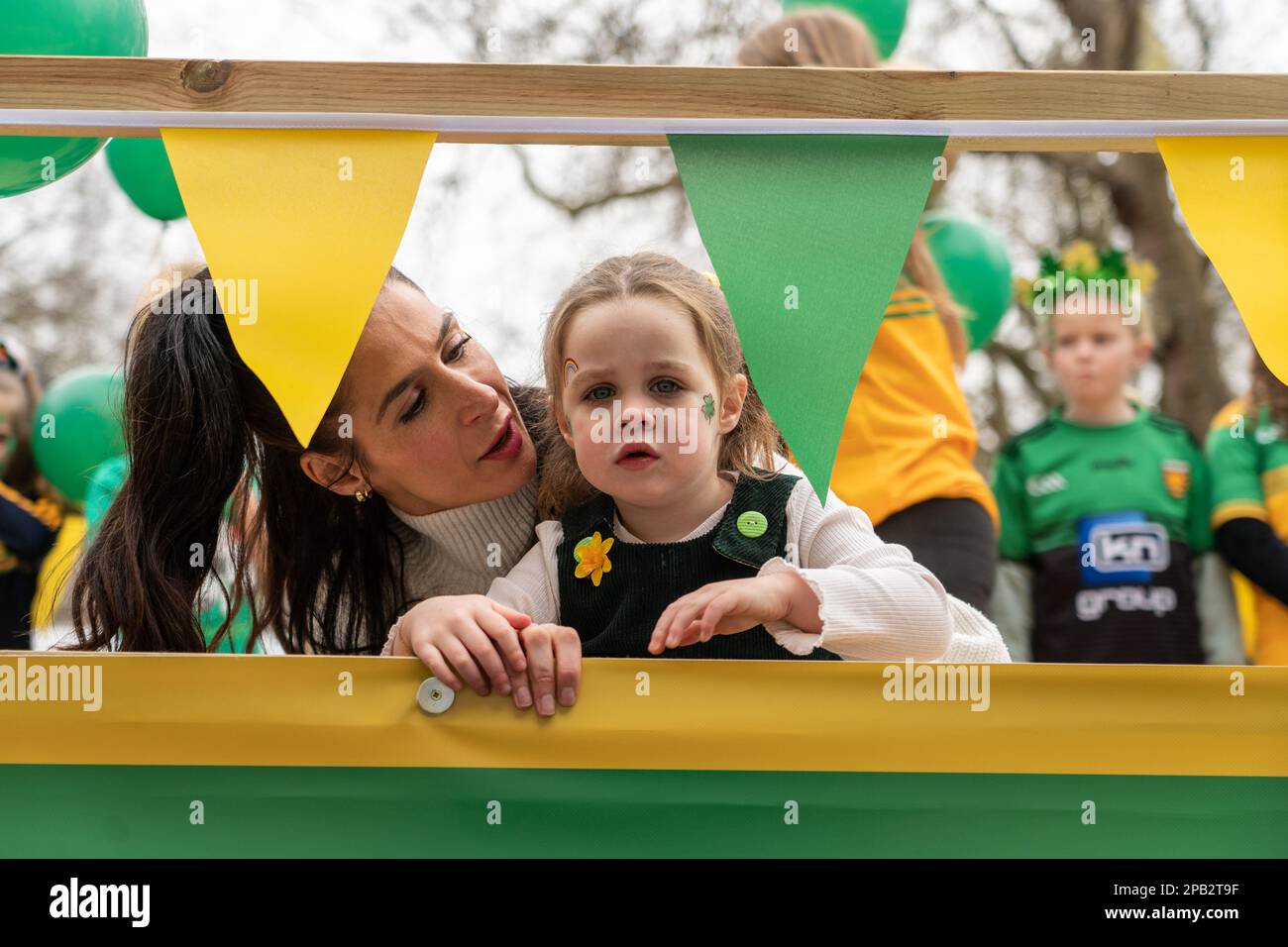 Jeff Moore - 3 year old joins her mother on a float at the St Patrick’s Day Festival parade in London. 12/03/2023 Stock Photo