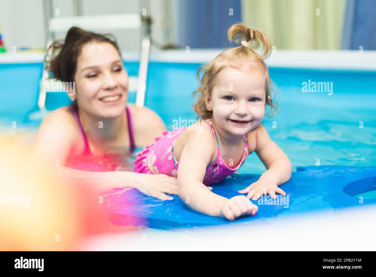 Cute baby learns to swim with mom in the pool Stock Photo Alamy
