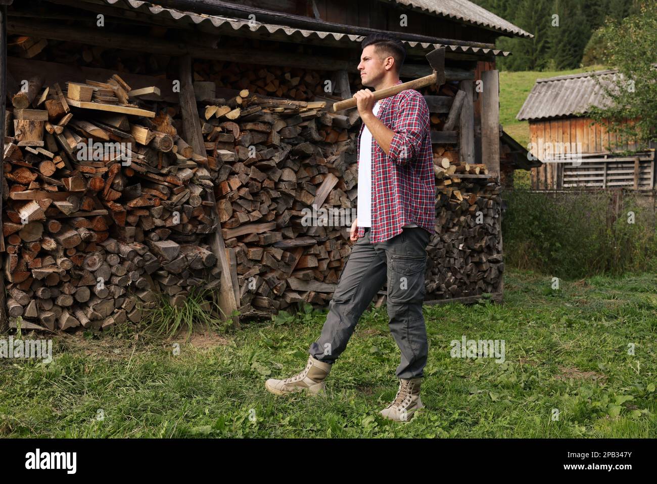 Man with ax near log pile outdoors Stock Photo