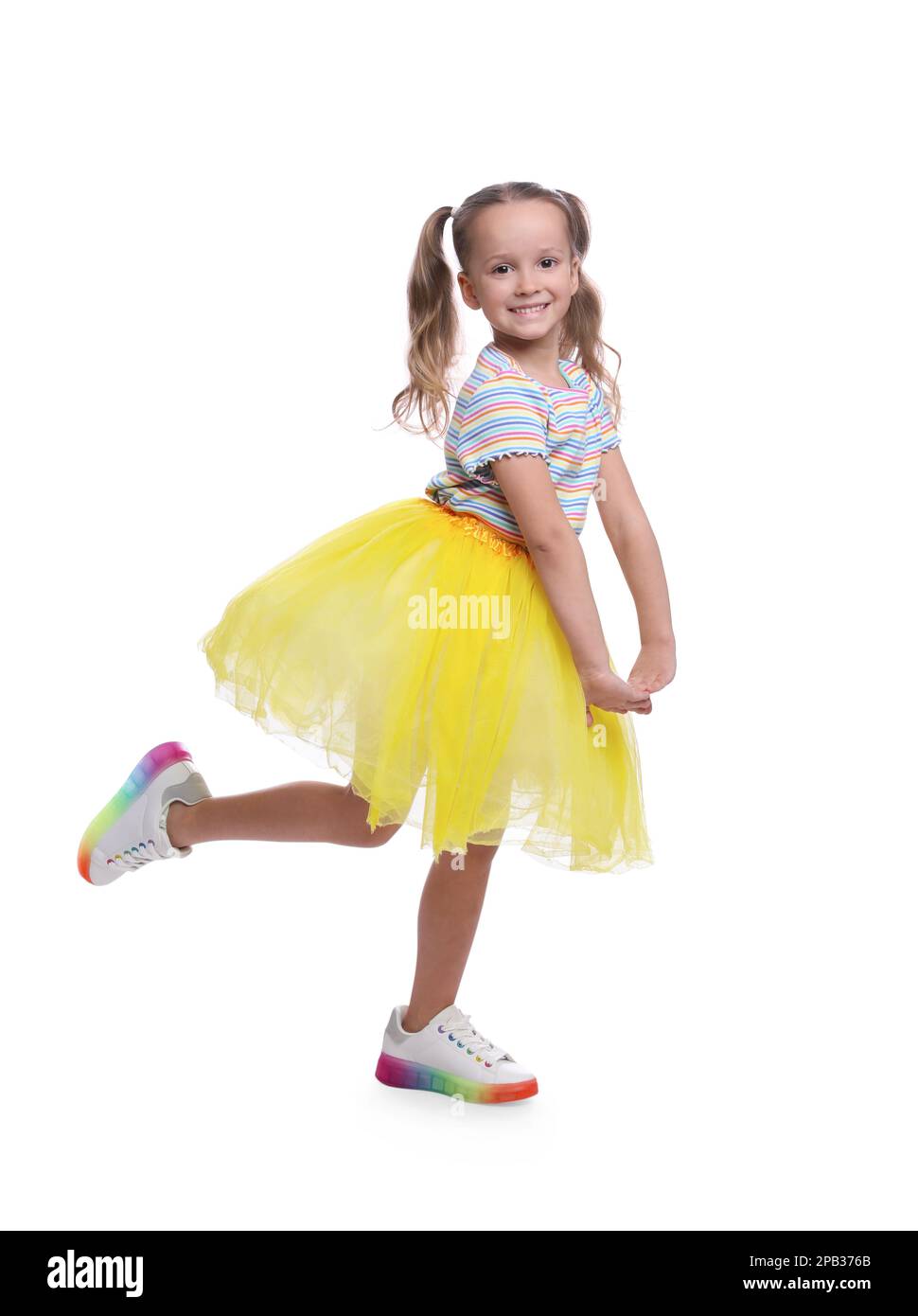 Cute little girl in tutu skirt dancing on white background Stock Photo