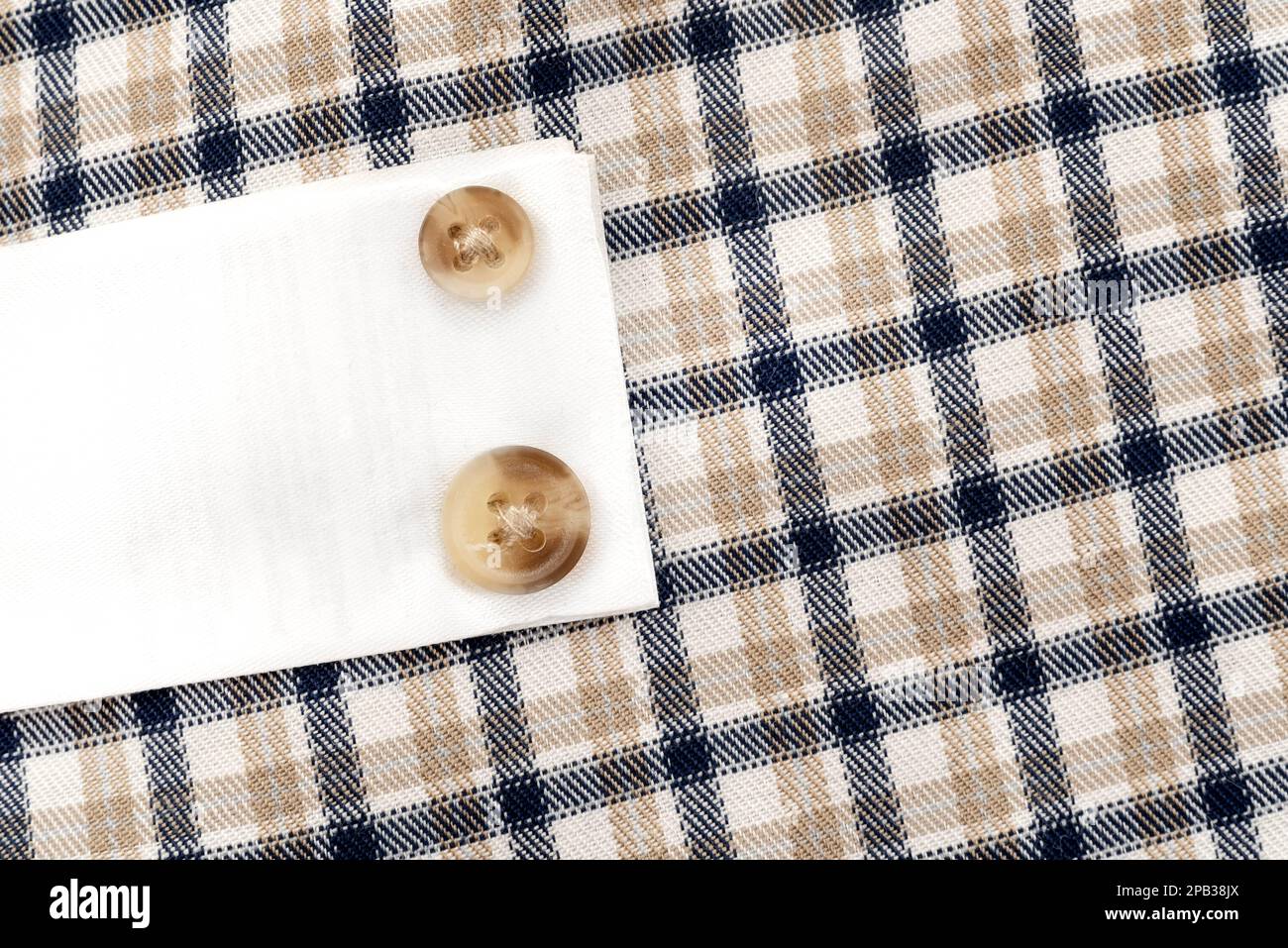 Buttons on a plaid shirt. Spare buttons sewn to the shirt Stock Photo