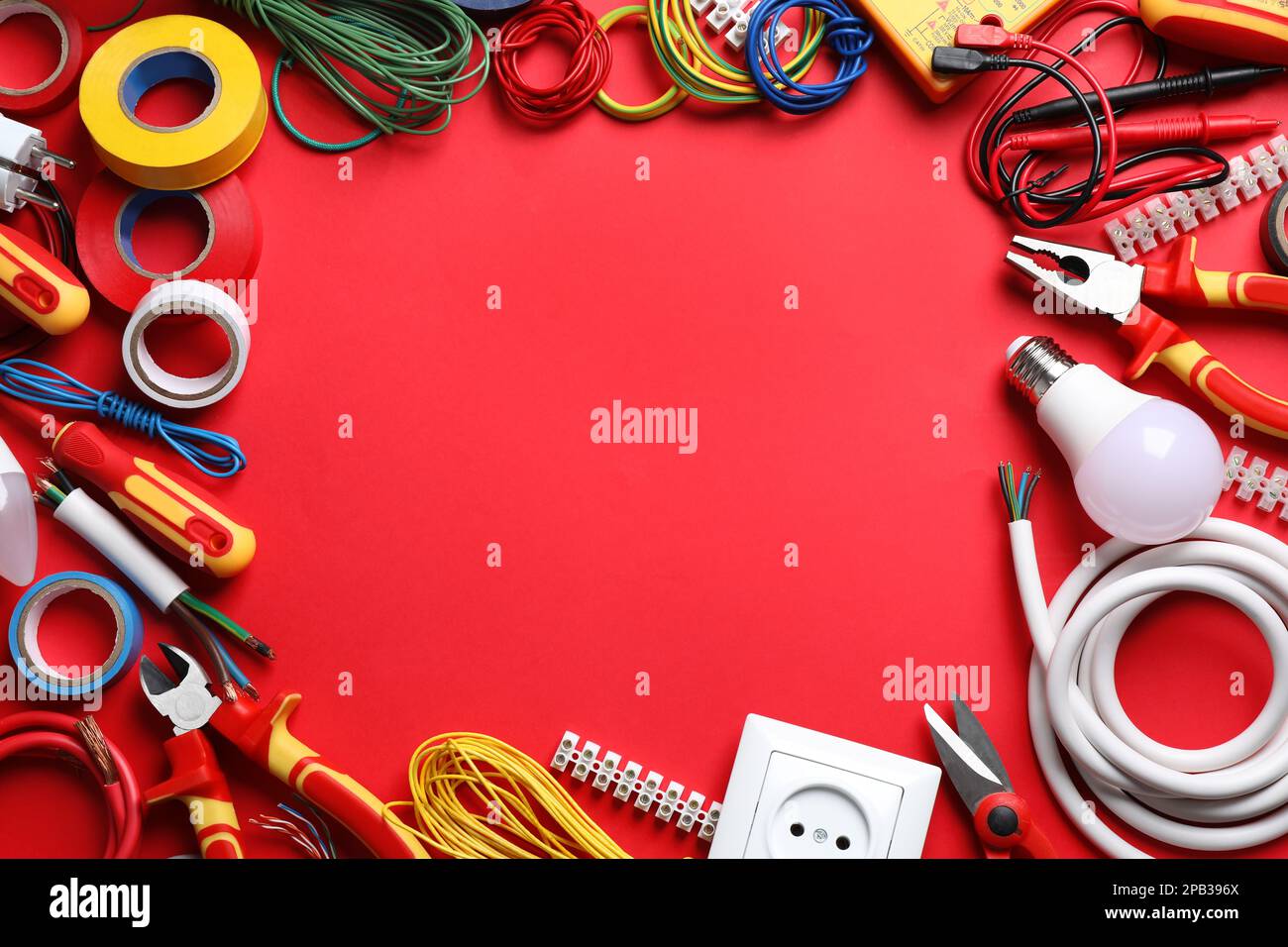 Frame of electrician's tools and accessories on red background, flat ...