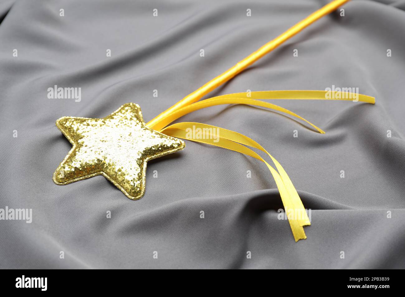 Beautiful golden magic wand on grey fabric Stock Photo