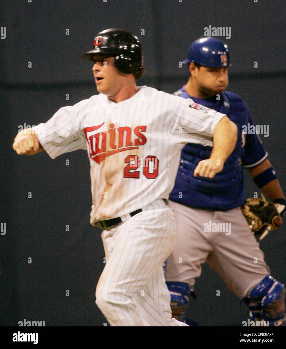 Minnesota Twins' Lew Ford, left, scores as Texas Rangers catcher