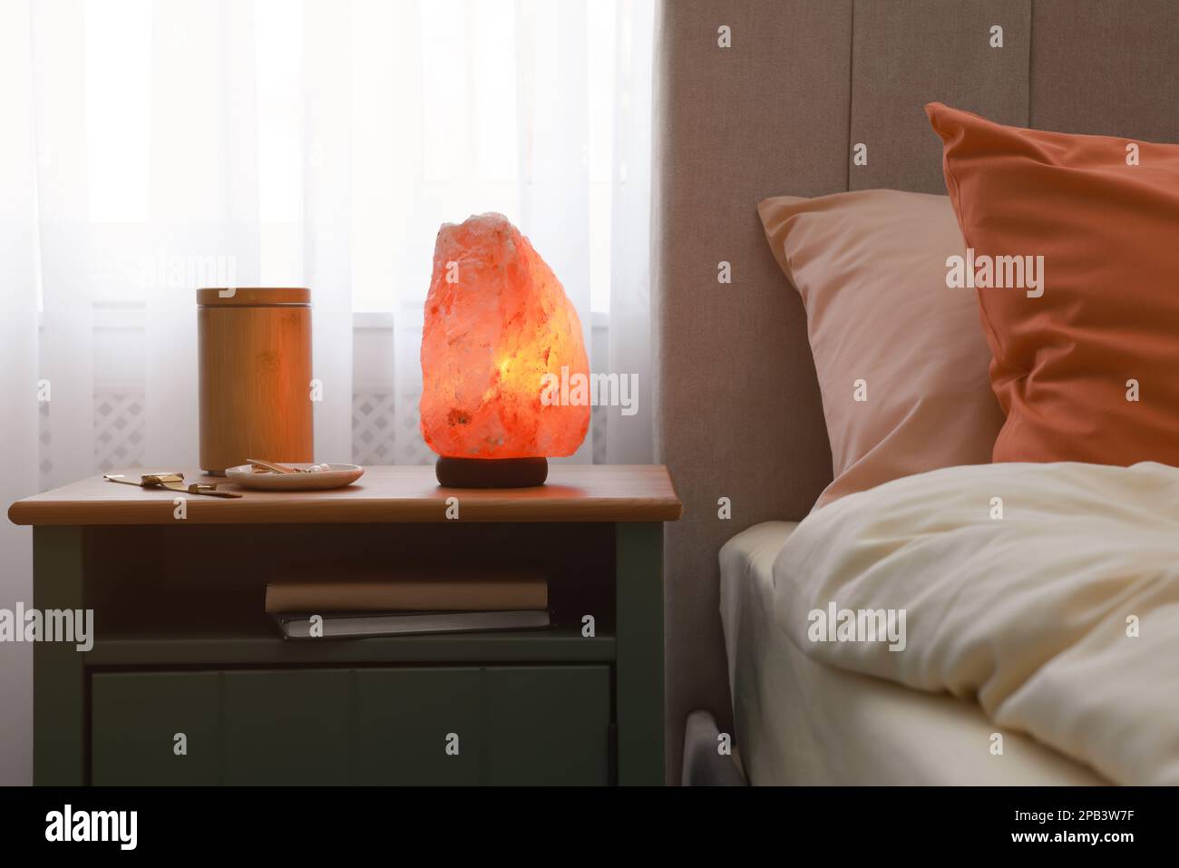 Himalayan salt lamp, air ionizer and accessories on nightstand in bedroom  Stock Photo - Alamy
