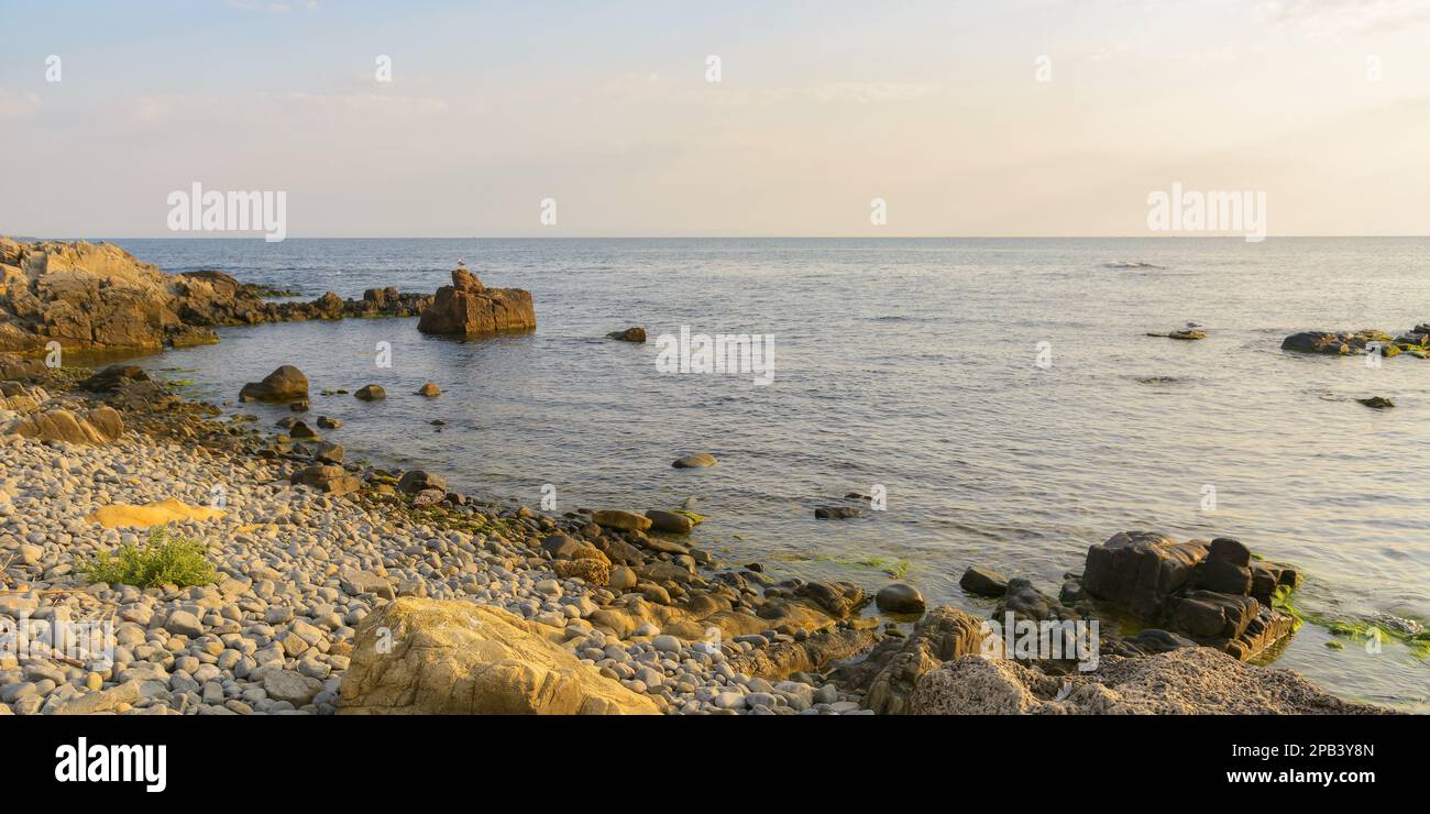 pebble coast at sunrise. summer vacation season at the sea Stock Photo
