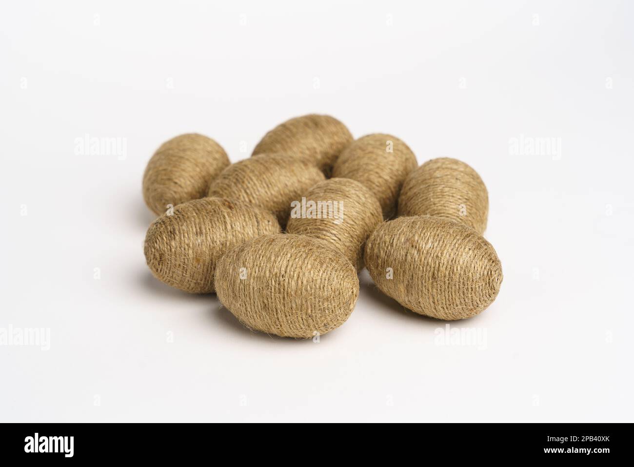 Hand wrapped easter eggs with jute twine, isolated white background. Studio Stock Photo